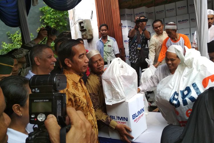 Presiden Joko Widodo membagi-bagikan paket sembako kepada warga kelurahan Penjaringan, Jakarta Utara, Selasa (13/6/2017).