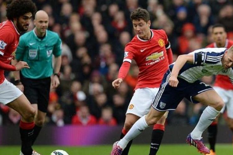 Dua gelandang Manchester United, Marouane Fellaini (kiri) dan Ander Herrera bertarung dengan penggawa West Bromwich Albion, Darren Fletcher, Sabtu (2/5/2015).