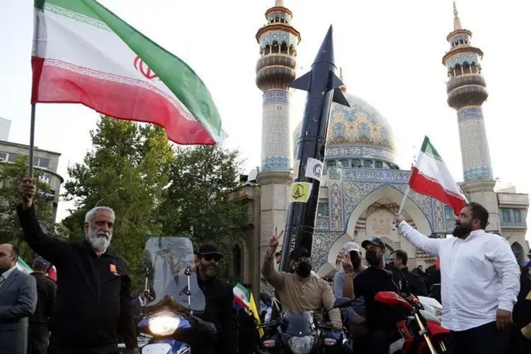 Warga Teheran merayakan serangan ke Israel pada Minggu (14/4/2024) dengan membawa rudal tiruan.