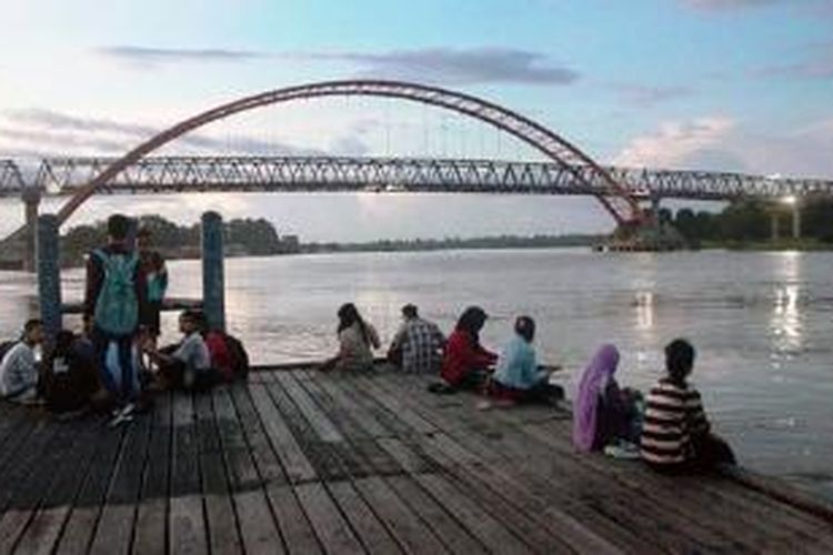 Warga Kota Palangkaraya, Kalimantan Tengah, menikmati senja di kafe tepi Sungai Kahayan, Jumat (10/4/2015). Keindahan alam, termasuk potensi wisata susur sungai, menjadi salah satu potensi wisata Palangkaraya. Namun, pengelolaan potensi itu belum optimal.