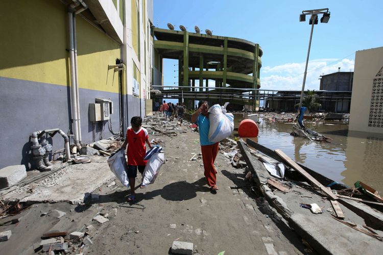 Warga menjarah barang di Grand Palu Mall usai gempa bumi di Pura, Kota Palu, Sulawesi Tengah, Minggu (30/9/2018). Gempa bermagnitudo 7,4 yang mengguncang Donggala dan Palu mengakibatkan ribuan bangunan rusak dan sedikitnya 420 orang meninggal dunia.