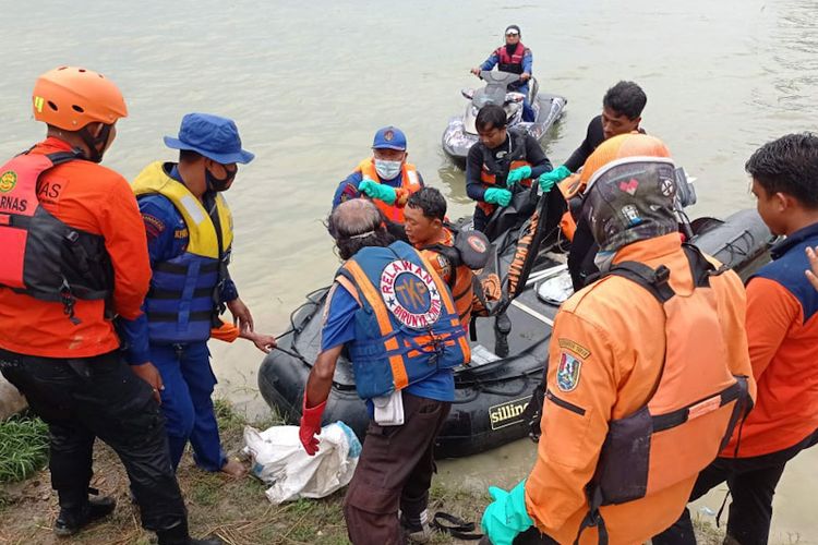 Petugas dari tim gabungan yang melakukan pencarian korban perahu terbalik di Waduk Gondang, Lamongan, saat melakukan evakuasi jasad korban ke daratan, Senin (7/2/2022).