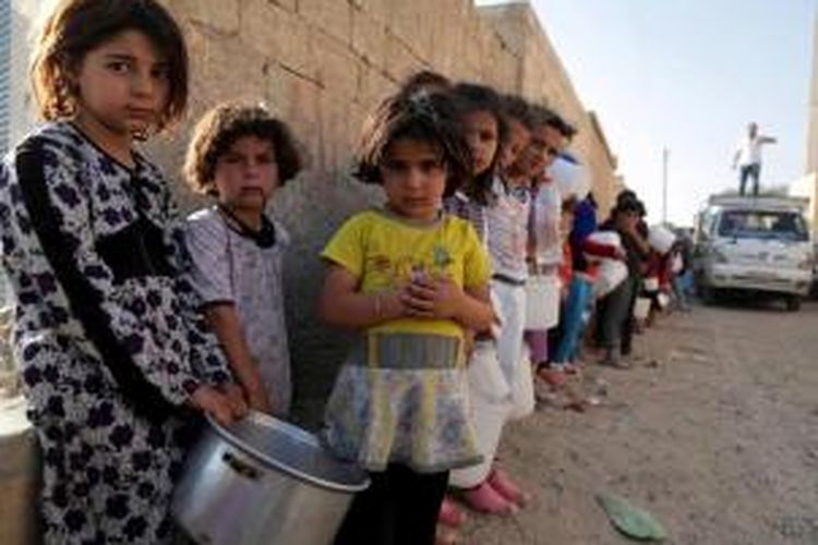 Anak Suriah mengantre makanan di utara Kota Raqqa, selama bulan suci Ramadhan, 14 Juli 2013. Kepala Koalisi Nasional Suriah Ahmad al-Assi telah mendukung seruan untuk gencatan senjata selama bulan suci Ramadhan dari Sekjen PBB Ban Ki-Moon.