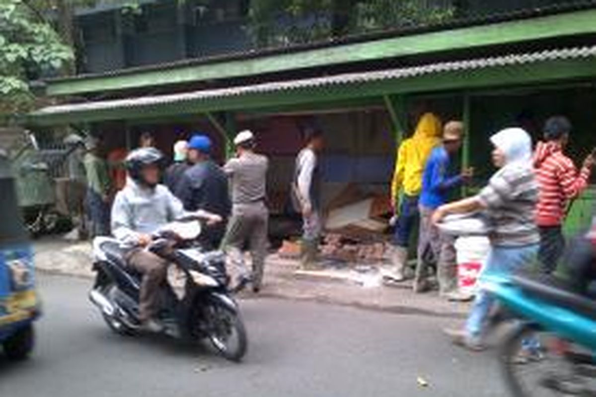 Tujuh kios di tepi Jalan Caringin dibongkar aparat Satpol PP karena didirikan di atas saluran air, Senin (1/10/2013). Pedagang yang menggunakan kios itu akan direlokasi ke Pasar Mete, Jakarta Selatan.