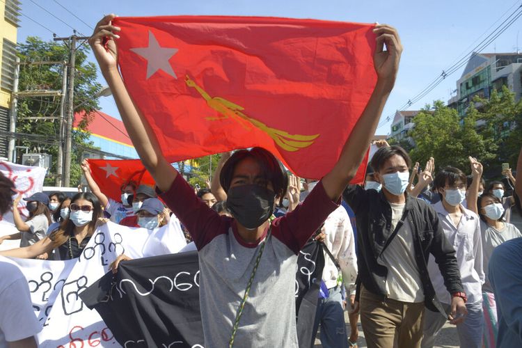 Pengunjuk rasa anti kudeta mengibarkan bendera partai Liga Nasional untuk Demokrasi (NLD) selama demonstrasi di Yangon, Myanmar, Jumat (14/5/2021).