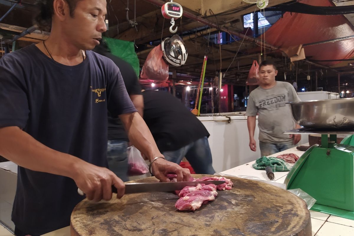 Salah satu pedagang daging sedang memotong potongan daging sapi untuk dijual di Pasar Anyar, Kota Tangerang, Banten, Selasa (19/1/2021) siang.