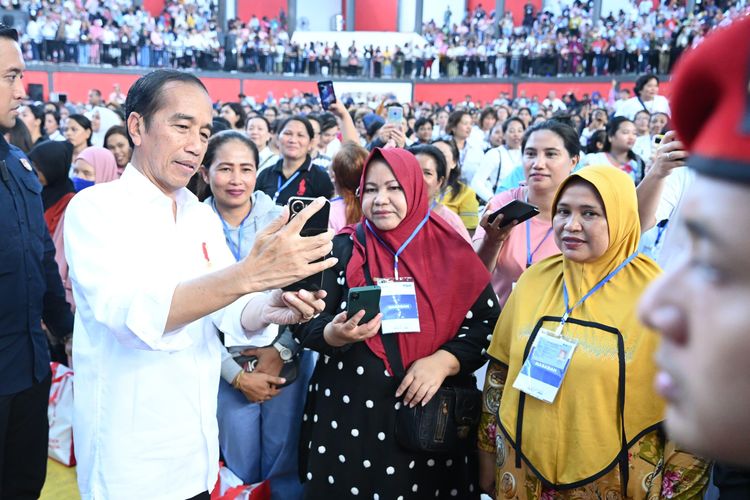Presiden Joko Widodo berswafoto dengan nasabah program Membina Ekonomi Keluarga Sejahtera (Mekaar) binaan Permodalan Nasional Madani (PNM) di Sport Hall & Convention, Kota Bitung, Jumat (23/2/2024).