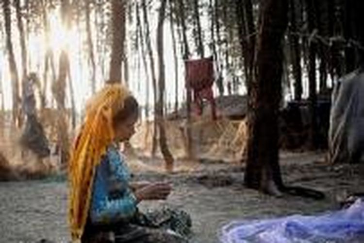 Mahada Khatum (32) memperbaiki jala penangkap ikan di luar tempat tinggalnya, di permukiman pengungsi Rohingya, di Shamalapur, Chittagong, Banglades, 11 April 2014. Pada 12 tahun lalu, ia meninggalkan kampung halamannya di Zomgara Baharchara, Meherulla, Myanmar, akibat kekerasan sektarian dan diskriminasi yang dialami warga etnis Rohingya. Selama beberapa tahun terakhir, tercatat ada ratusan ribu warga Rohingya meninggalkan Myanmar untuk mengungsi ke Banglades.