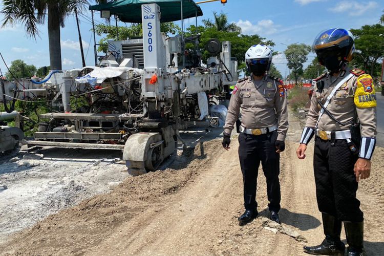 Kasatlantas Polres Lamongan AKP Aristianto Budi Sutrisno (kanan), saat meninjau perbaikan jalan poros nasional di Desa Pandanpancur, Deket, Lamongan, Minggu (27/12/2021).