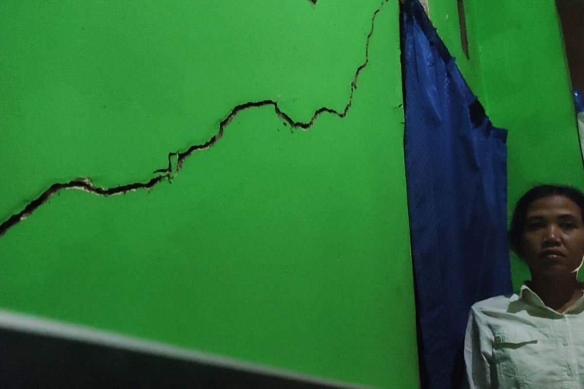 Siti Rokayah (37) menunjukkan retakan di tembok ruang tamunya di Desa Gumulungtonggoh, Kecamatan Greged, Kabupaten Cirebon, Selasa (22/8/2023)