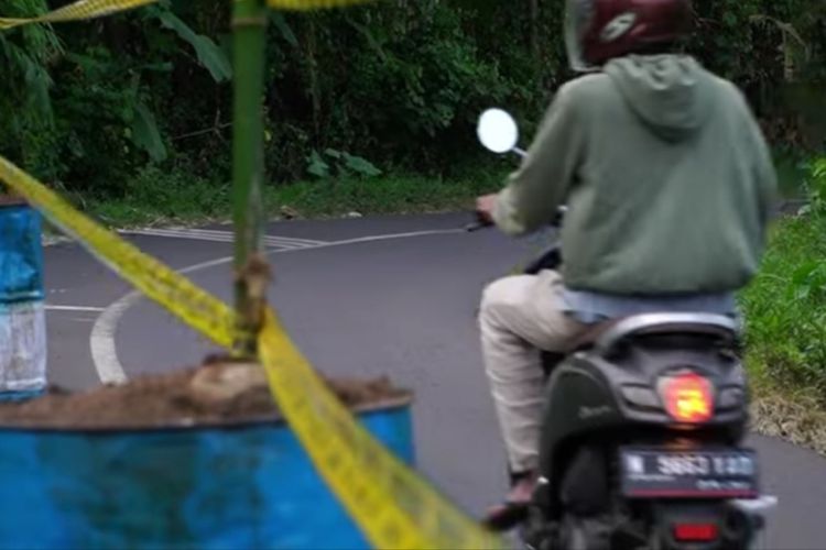 Penanda jalan terpasang di tikungan jalan yang longsor