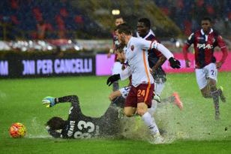 Gelandang AS Roma, Alessandro Florenzi (24), coba menaklukkan penjaga gawang Bologna, Antonio Mirante, ketika kedua tim bertemu pada lanjutan Serie A, Sabtu (21/11/2015). Sepanjang pertandingan, Stadion Renato Dall'Arra ini diguyur hujan deras.