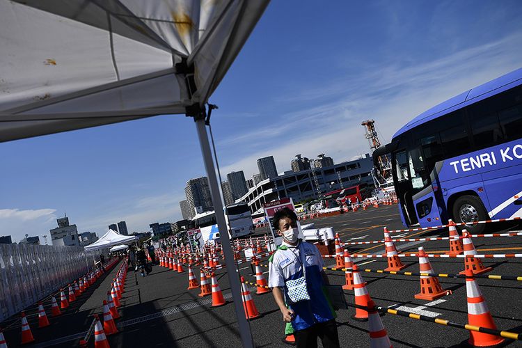 Petugas menunggu tibanya bus yang akan membawa peserta Olimpiade Tokyo 2020 di Media Transport Mall, Tokyo, Jepang, Rabu (21/7/2021). Para peserta Olimpiade Tokyo 2020 harus menggunakan bus atau transportasi khusus selama kegiatan olahraga tersebut berlangsung untuk menghindari kemungkinan tertularnya Covid-19.