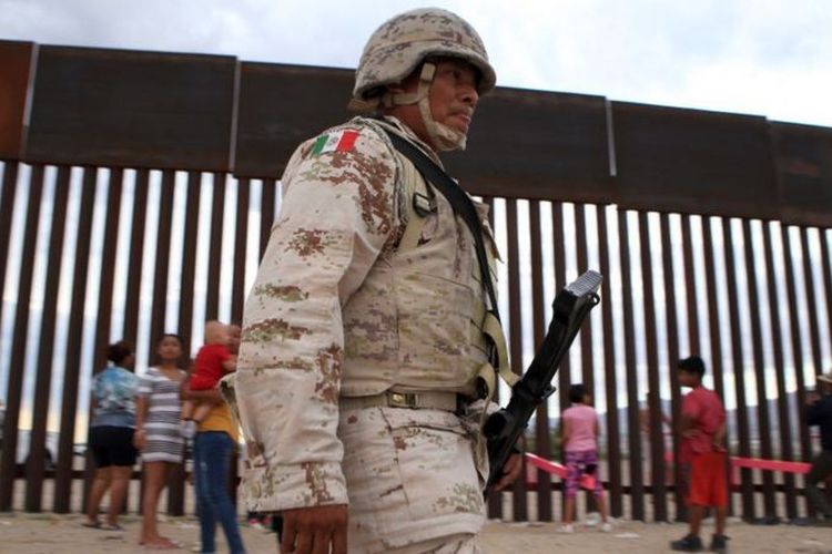 Polisi berjaga di tembok perbatasan AS-Meksiko.