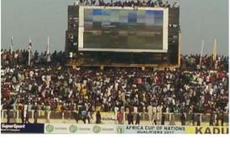 Penonton nekat menyaksikan pertandingan Nigeria vs Mesir pada kualifikasi Grup G Piala Afrika, Jumat (25/3/2016), dari atas papan skor.