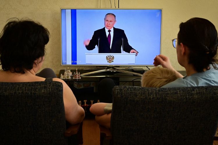 Sebuah keluarga menonton siaran TV pidato kenegaraan tahunan Presiden Rusia Vladimir Putin di Moskwa pada Selasa (21/2/2023). Putin mengatakan pada Selasa, bahwa dia menangguhkan partisipasi Rusia dalam perjanjian START Baru, pakta pengendalian senjata nuklir AS-Rusia terakhir yang tersisa.