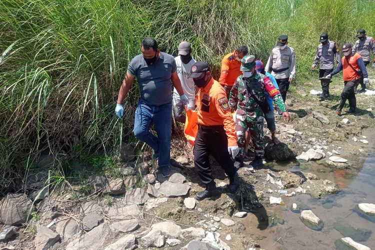 EVAKUASI—Tim mengevakuasi jasad  kakek Sarimun (65) ) di Sungai Bemgawan Madiun, Kabupaten Madiun, Jawa Timur, Rabu (25/8/2021).