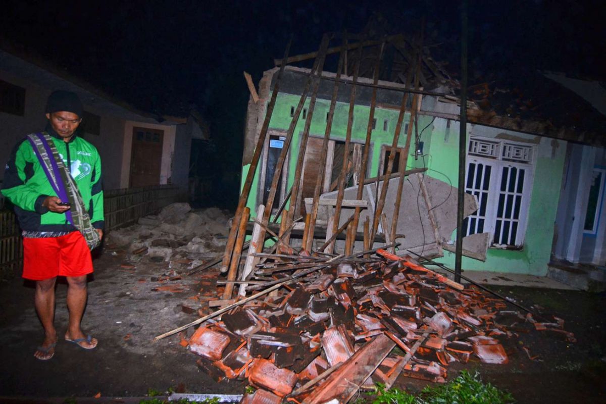 Warga menyaksikan rumah yang ambruk akibat gempa bumi di Desa Sumelap, Kota Tasikmalaya, Jawa Barat, Sabtu (16/12/2017). Gempa berkekuatan 6,9 skala richter dan berpotensi tsunami dilaporkan terjadi pada Jumat (15/12/2017) pukul 23:47:58 WIB di wilayah Tasikmalaya. 