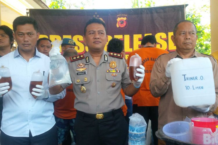 Kepala Polres Sukabumi, AKBP Nasriadi (tengah) memperlihat barang bukti bahan-bahan minuman keras oplosan saat konferensi pers di Palabuhanratu, Sukabumi, Jawa Barat, Selasa (10/4/2018). 