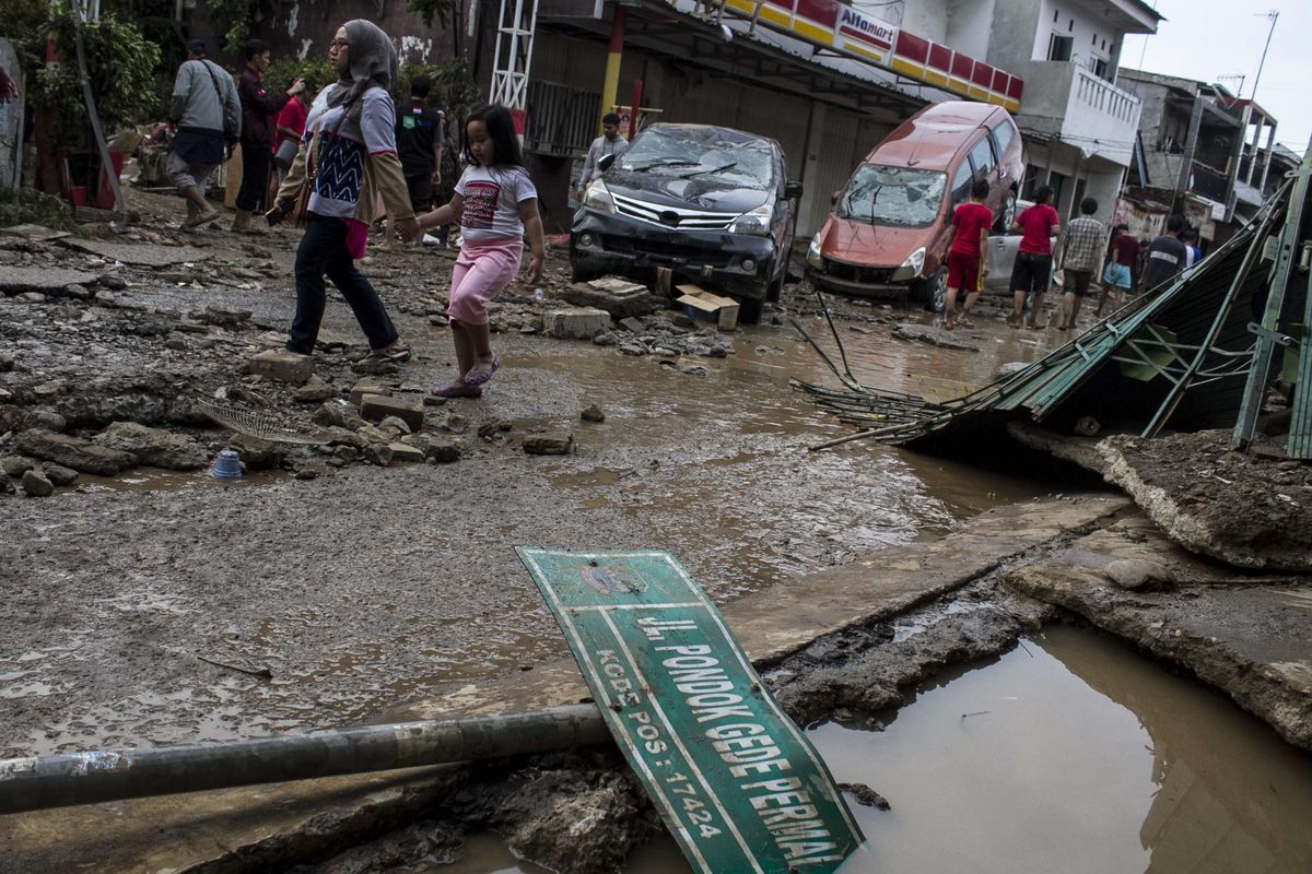 Sejumlah warga melintas di area pemukiman yang sempat terendam banjir di kawasan Pondok Gede Permai, Jati Asih, Bekasi, Jawa Barat, Kamis(2/1/2020). Banjir di kawasan tersebut, merupakan banjir terparah di wilayah Bekasi.