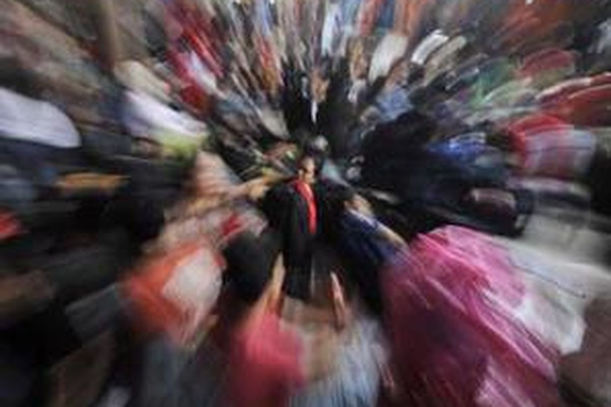 Pemudik yang akan menggunakan kereta api tujuan Jawa Tengah, Jawa Timur, dan DI Yogyakarta, menunggu kedatangan kereta di Stasiun Pasar Senen, Jakarta, Sabtu (27/9). Lonjakan penumpang kereta api membuat pemudik berdesak-desakan di dalam kereta. 