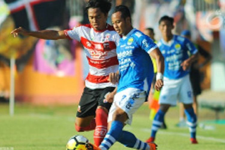 Pemain Madura United, Rendika Rama, sedang merebut bola yang dibawa oleh pemain Persib Bandung, Atep, pada laga yang digelar di Stadion Ratu Pamelingan, Pamekasan, Jawa Timur (4/5/2018)