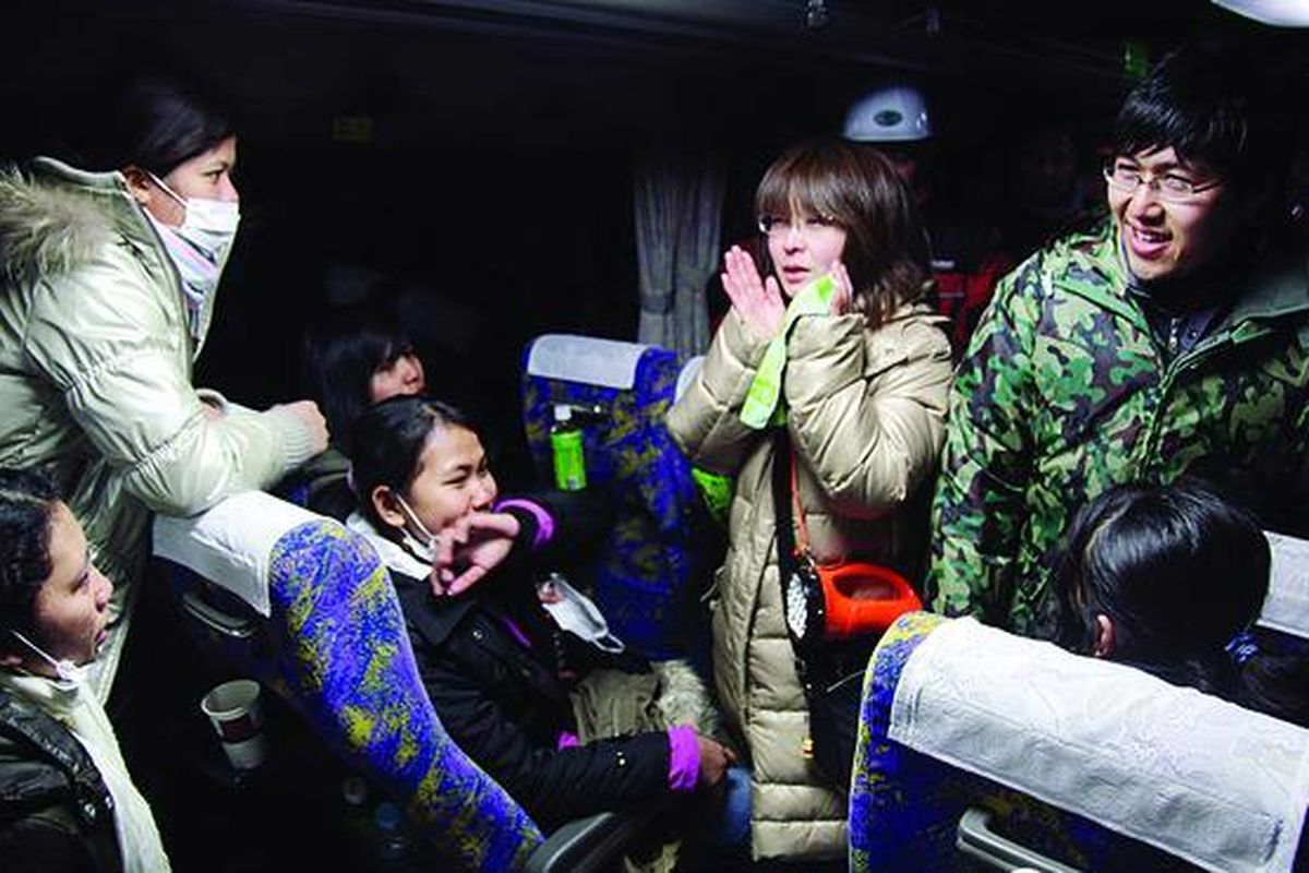 Siswa Jepang (kanan) di pengungsian Sekolah Menengah Atas Torio, Kesennuma, Prefektur Miyagi, mengantar 33 remaja lulusan sekolah menengah kejuruan Indonesia hingga ke dalam bus, Rabu (16/3) malam. Perpisahan sesama korban gempa dan tsunami yang berlainan bangsa itu terasa sangat berat.