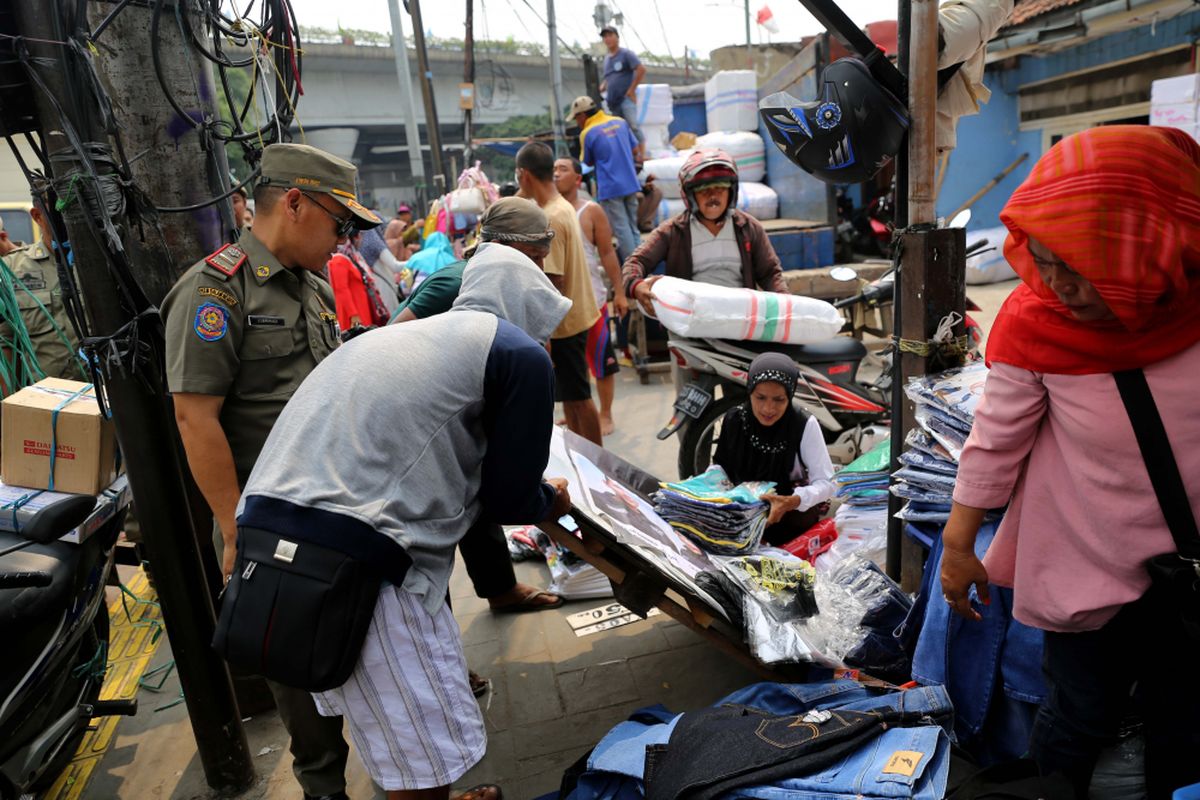 Petugas Satpol PP melakukan penertiban kepada pedagang kaki lima yang berjualan di kawasan Pasar Tanah Abang, Jakarta, Rabu (17/5/2017). Penertiban dilakukan setiap hari menyusul mulai banyaknya PKL yang berjualan di trotoar dan jalan kawasan Pasar Tanah Abang.