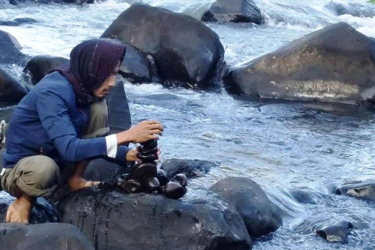 Seorang pegiat lingkungan sedang melakukan susun batu di aliran Sungai Cibala Pulang, Sukanagara, Cianjur, Jawa Barat, Minggu (16/06/2019)