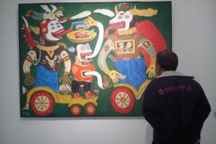 Pengunjung Museum Art Mon Decor sedang melihat sebuah lukisan yang dipamerkan di museum yang berada di Jakarta. 