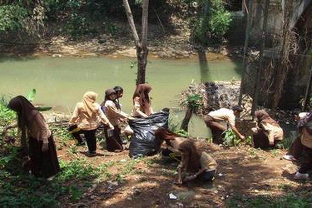 Anggota pramuka membersihkan sampah di tepi Kali Ciliwung, Kecamatan Pancoran Mas, Depok, Sabtu (24/9
