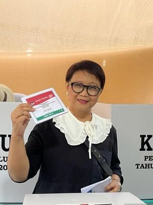 Menteri Luar Negeri Retno Marsudi bersiap memasukkan surat suara ke kotak suara saat memilih di TPS 156 di Kompleks Pesona Khayangan Depok, Jawa Barat, Rabu (14/2/2024).