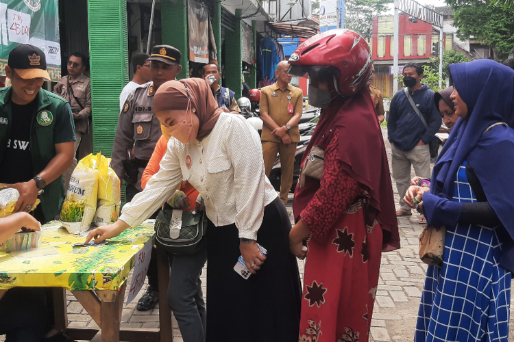 Warga antre beras dalam operasi pasar yang digelar Pemkab Lumajang di Pasar Sukodono, Senin (27/2/2023).