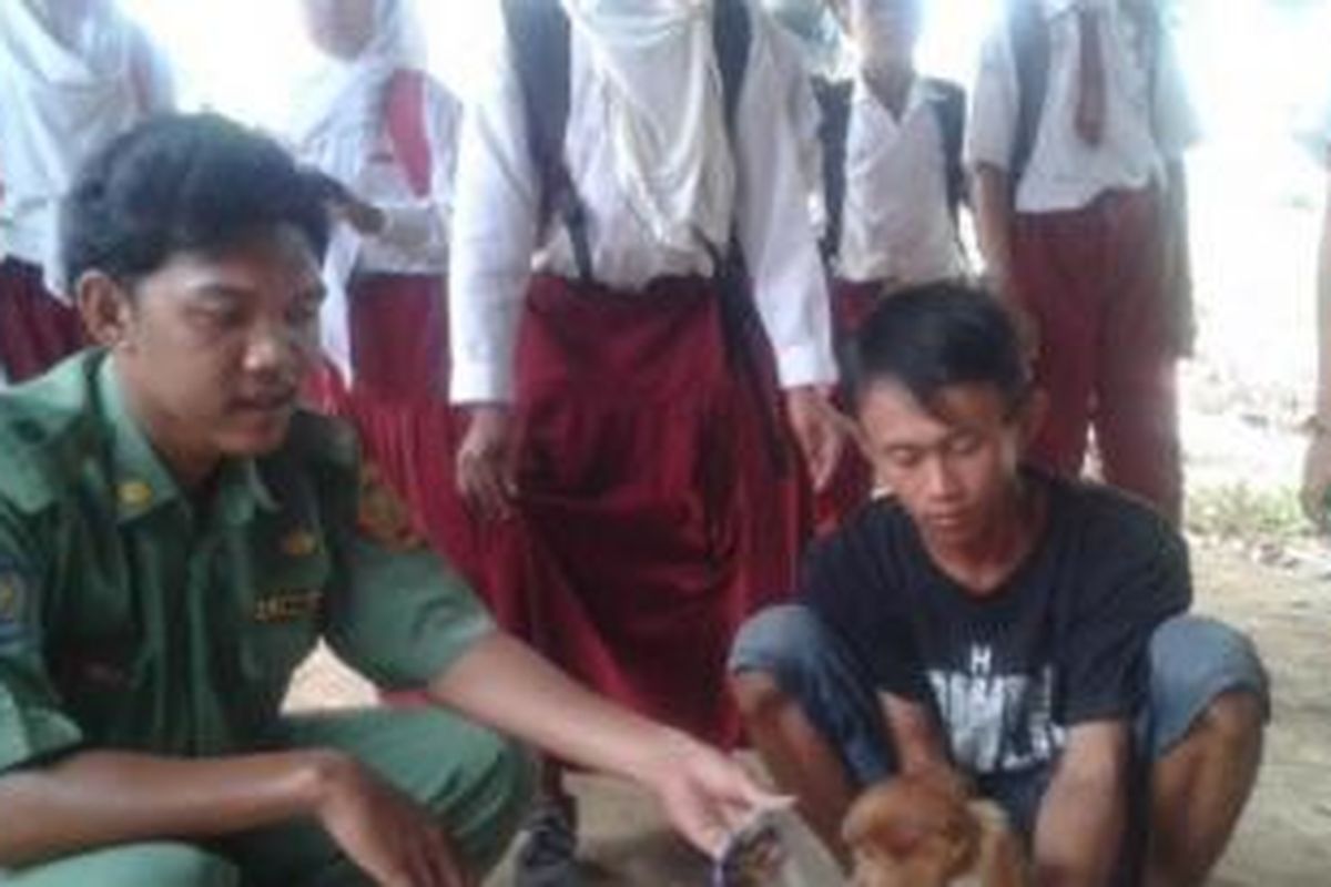 Warga menyaksikan bekantan yang diamankan di rumah tokoh masyarakat Desa Sungai Rutas, Herman. 

