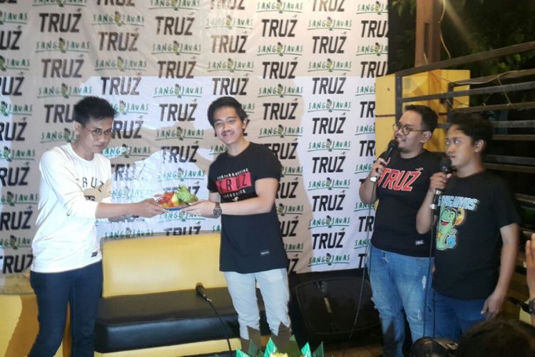 Putra bungsu Presiden Jokowi, Kaesang Pangerap menyerahkan potongan tumpeng kepada Co Founder Truz, Reza Agus Wijaya saat membuka toko barunya di Jalan MH Thamrin 9A, Manahan, Kota Solo, Minggu (25/2/2018) malam. 