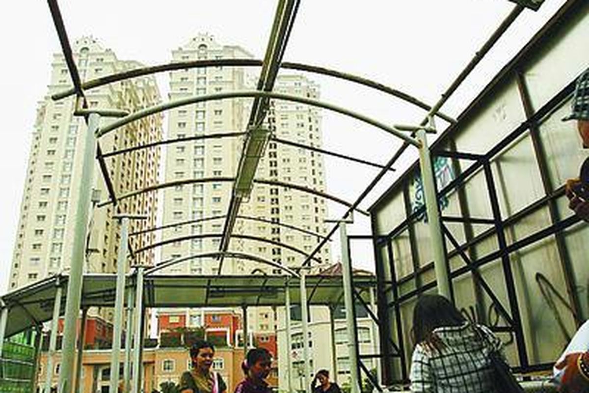 Warga melintas di bawah atap yang hilang di jembatan penyeberangan orang di Halte Olimo, Jakarta Barat, Selasa (10/6). Warga menjadi tidak terlindungi dari panas terik matahari maupun saat hujan turun.  