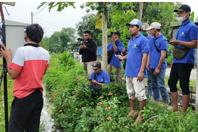 Teknisi sedang melakukan pengecekan di lahan pertanian. 