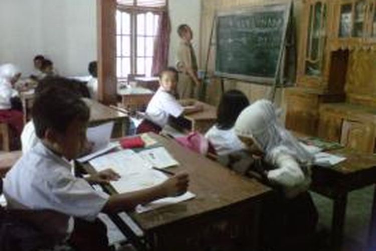Beberapa siswa SD Negeri Tempak 2 Kecamatan Candimulyo, Kabupaten Magelang, mengikuti kegiatan belajar mengajar di rumah warga karena ruang kelas roboh dan direnovasi, Selasa (11/11/2014).