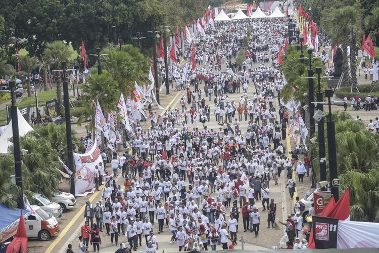 Pendukung pasangan Capres dan Cawapres nomor urut 01, Joko Widodo (Jokowi)-Maruf Amin berjalan menuju lokasi Konser Putih Bersatu dalam rangka kampanye akbar pasangan pasangan tersebut di Gelora Bung Karno (GBK), Jakarta, Sabtu (13/4/2019).