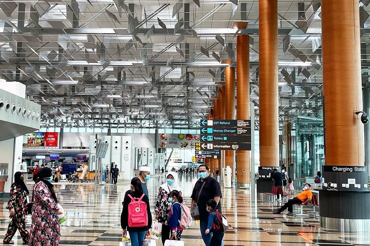 Segelintir penumpang pesawat terlihat di Terminal 3 Keberangkatan Bandara Internasional Changi, Singapura, Minggu sore (17/01/2021)