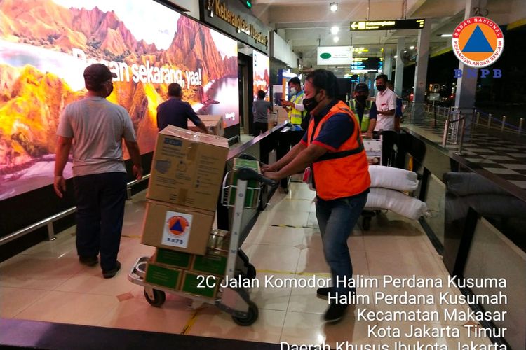 Petugas logistik dan peralatan BNPB membantu proses pengiriman bantuan bagi warga terdampak bencana banjir bandang di Kabupaten Flores Timur melalui Bandara Internasional Halim Perdana Kusuma, Jakarta, Minggu (4/4/2021) malam.