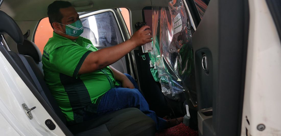 Sebelum menjalankan aktivitasnya sebagai mitra pengemudi GrabCar, Robertus Satya rajin untuk membersihkan kabin kendaraannya dengan disinfektan. 