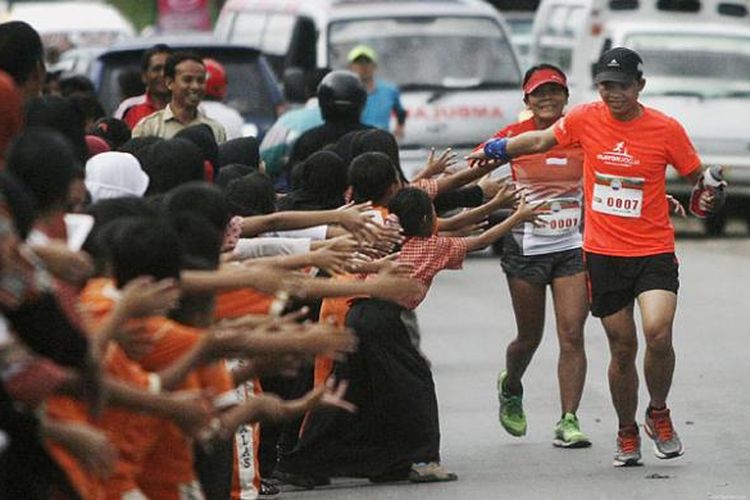 Dino Eka Putra dan Lily Suryani, peserta lomba ultramaraton sejauh 320 kilometer Trans-Sumbawa 200, disambut pelajar dan masyarakat di Sumbawa, Nusa Tenggara Barat, Rabu (8/4/2015). Ultramaraton yang harus diselesaikan peserta maksimal 67 jam ini diselenggarakan dalam rangkaian peringatan 200 tahun meletusnya Gunung Tambora yang menewaskan 71.000 orang pada 1815.
