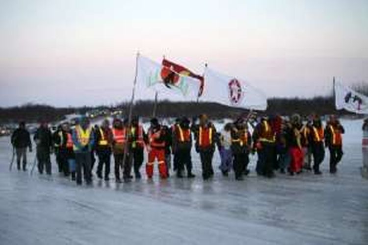 Pemuda dari tiga komunitas First Nation menyeberangi sungai Attawapiskat yang beku selama pawai pada 7 April 2016. Mereka mendukung upaya untuk mengatasi upaya bunuh diri yang terus meningkat di Attawapiskat, Ontario utara. 