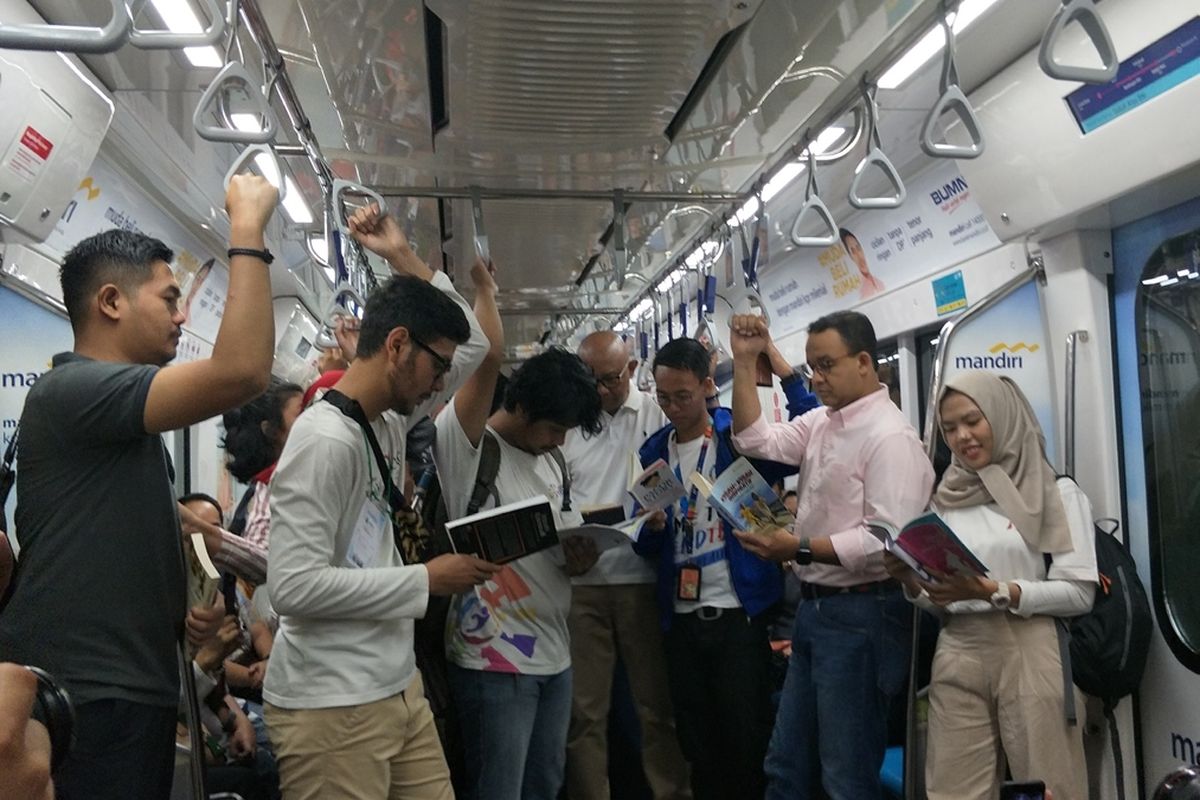 Gubernur DKI Jakarta Anies Baswedan membaca buku di dalam kereta MRT selama perjalanan dari Stasiun Bundaran HI menuju Stasiun Lebak Bulus, Minggu (8/9/2019).