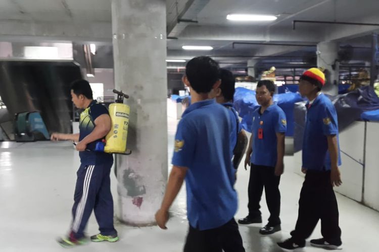 Petugas dari Dinkes Pemkot Denpasar menyemprotkan disenfektan di areal Pasar Badung, Minggu (8/3/2020) malam.