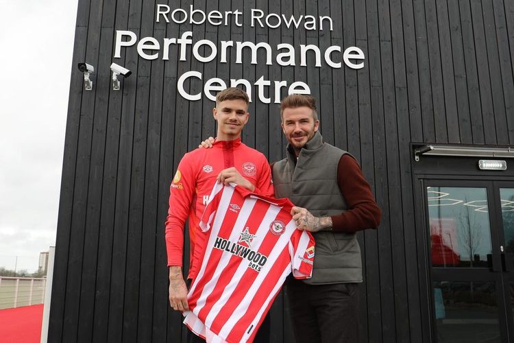 Legenda Manchester United, David Beckham, berpose bersama anaknya, Romeo, di depan markas latihan akademi Brentford. Romeo Beckham dipinjam Brentford B dari kubu MLS, Inter Miami.