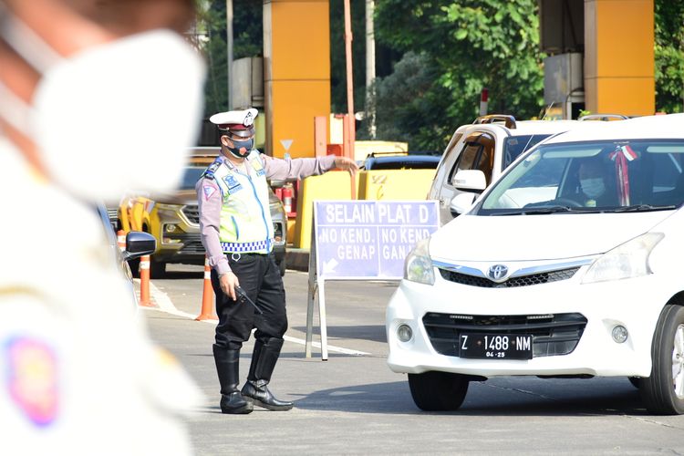 Petugas tengah menerapkan ganjil genap di depan pintu tol Pasteur. Ganjil Genap dilakukan di lima tol Kota Bandung untuk mengontrol arus kendaraan yang masuk ke Bandung setiap Akhir pekan.