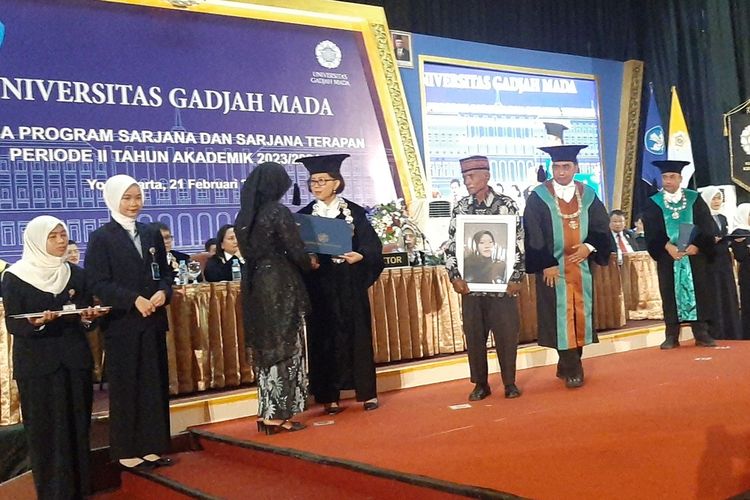 Rektor UGM Prof Ova Emilia saat menyerahkan ijazah Dewi Sekar Rumpoko kepada sang ibu Ngadinah. Di atas podium juga tampak sang ayah Jono membawa foto almarhum putrinya Dewi Sekar Rumpoko.