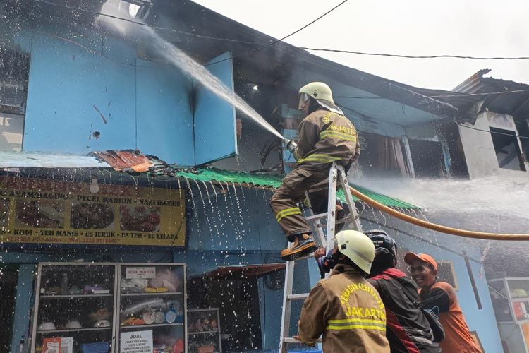 Petugas pemadam kebakaran dibantu dengan warga berjibaku memadamkan korban api yang melahap habis bangunan permanen dan semi permanen di Jalan Simprug Golf, Kebayoran Lama, Jakarta Selatan Minggu (21/8/2022). Sebanyak 120 KK pun ikut terdampak akibat musibah kebakaran yang terjadi.